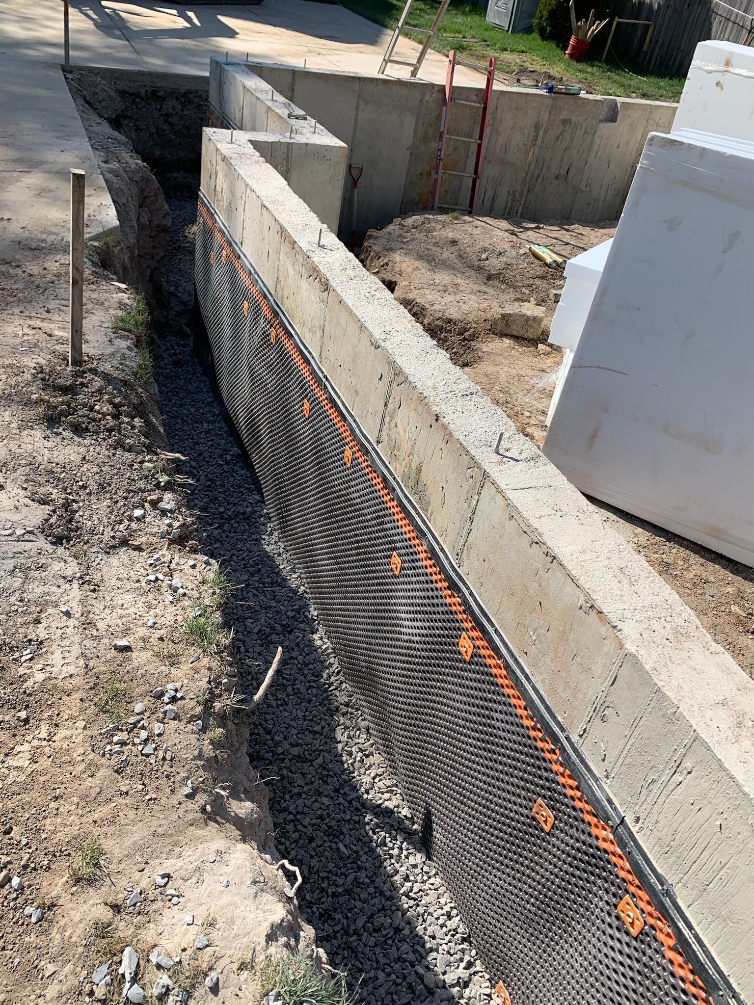 A concrete wall is being built next to a sidewalk.