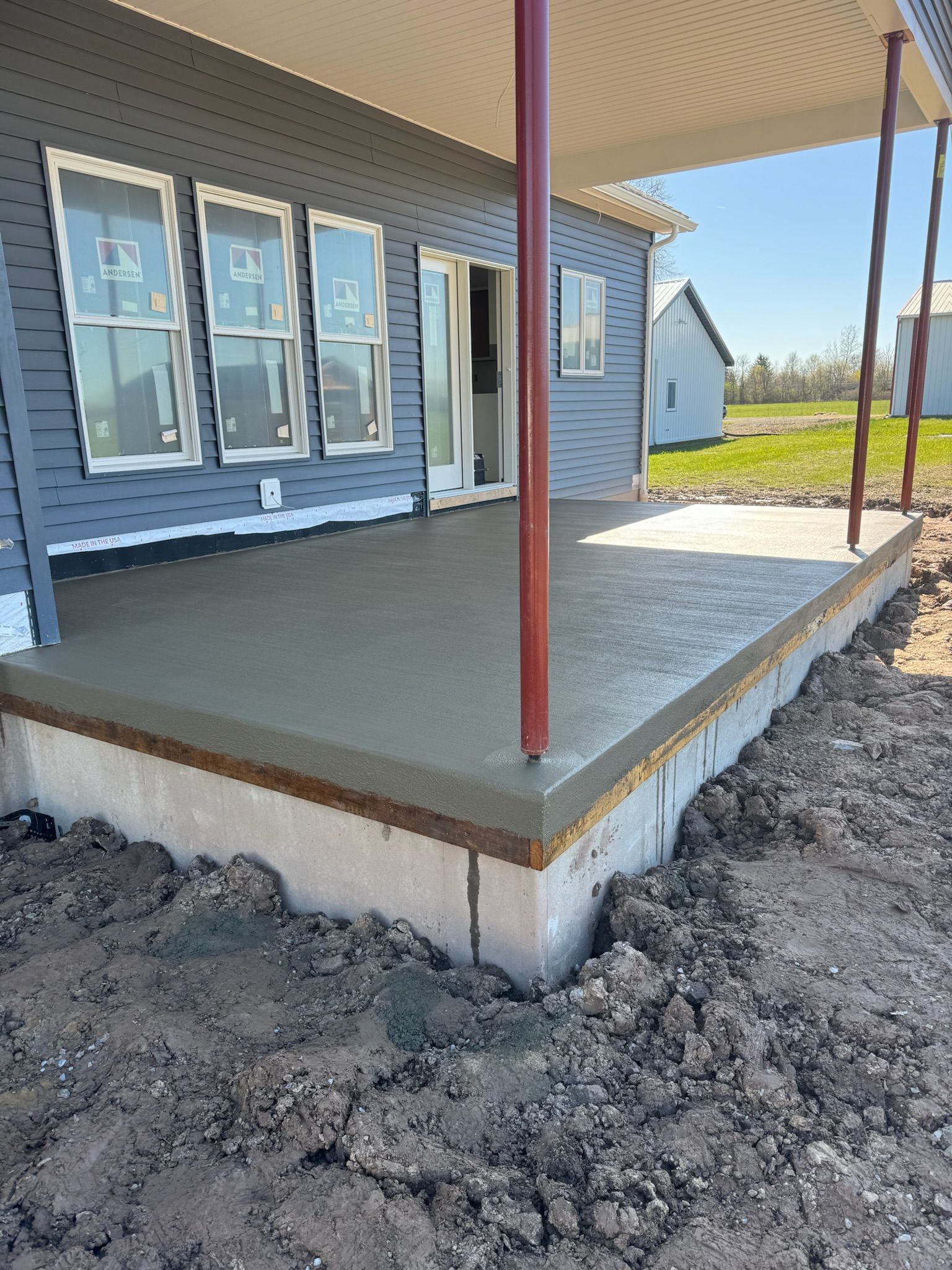A concrete deck is being built in front of a house.