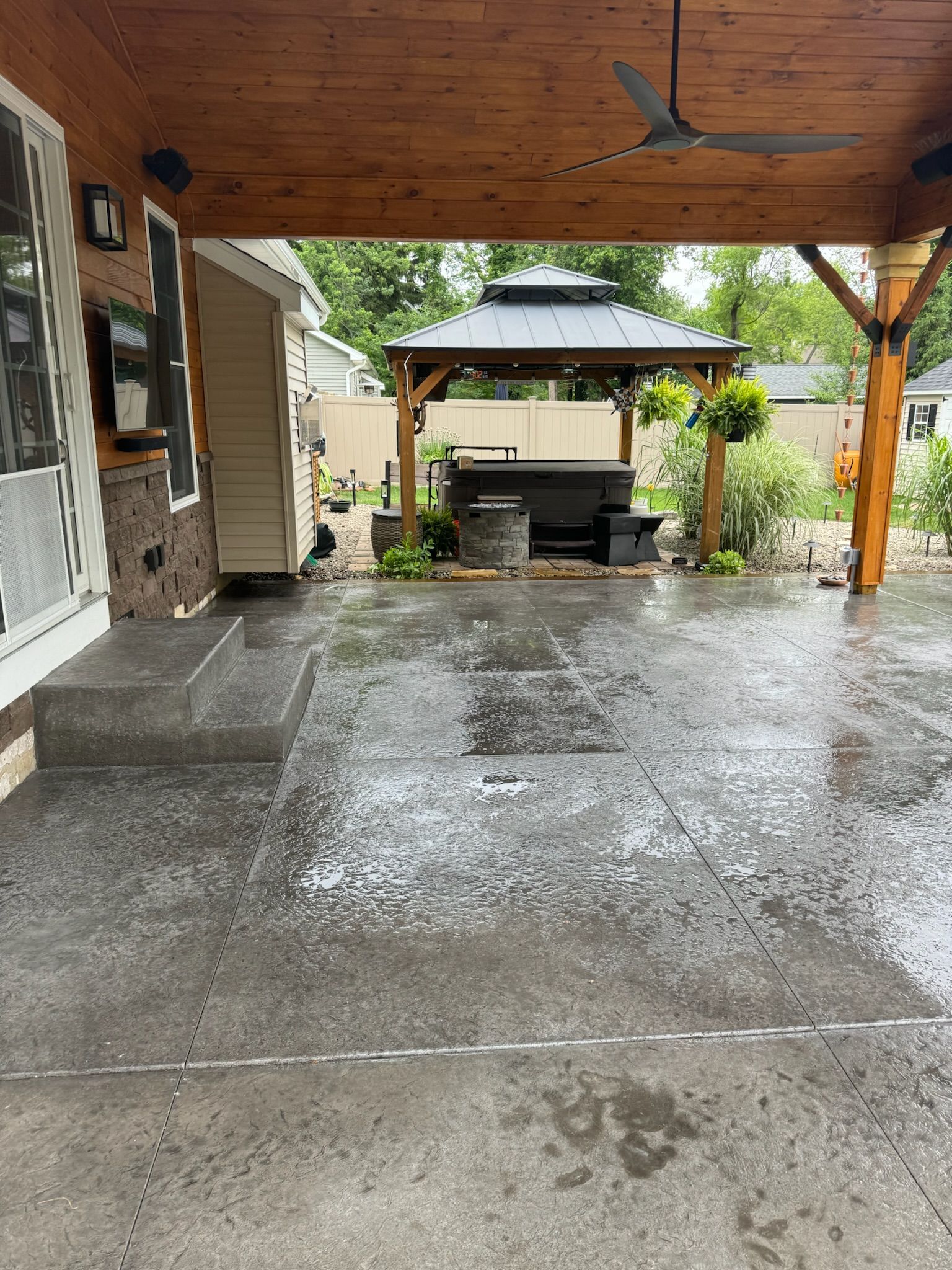 A covered patio with a gazebo and a ceiling fan.
