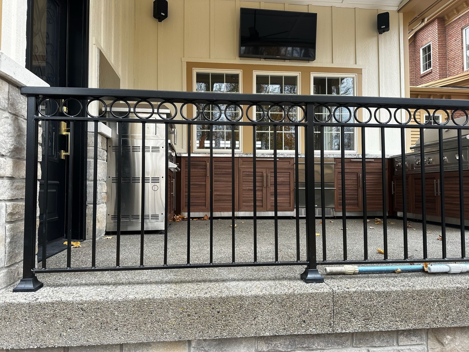 A wrought iron railing on a porch of a house.
