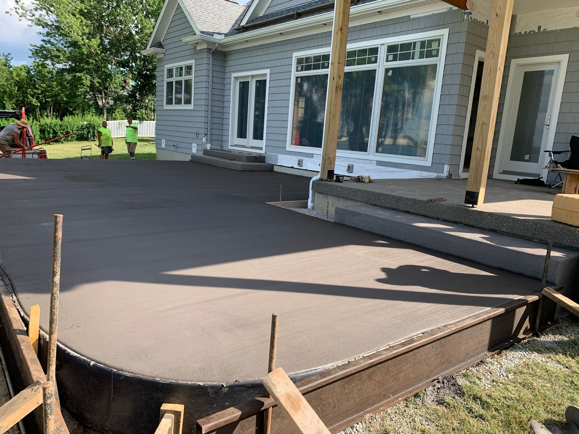 A concrete patio is being built in front of a house.