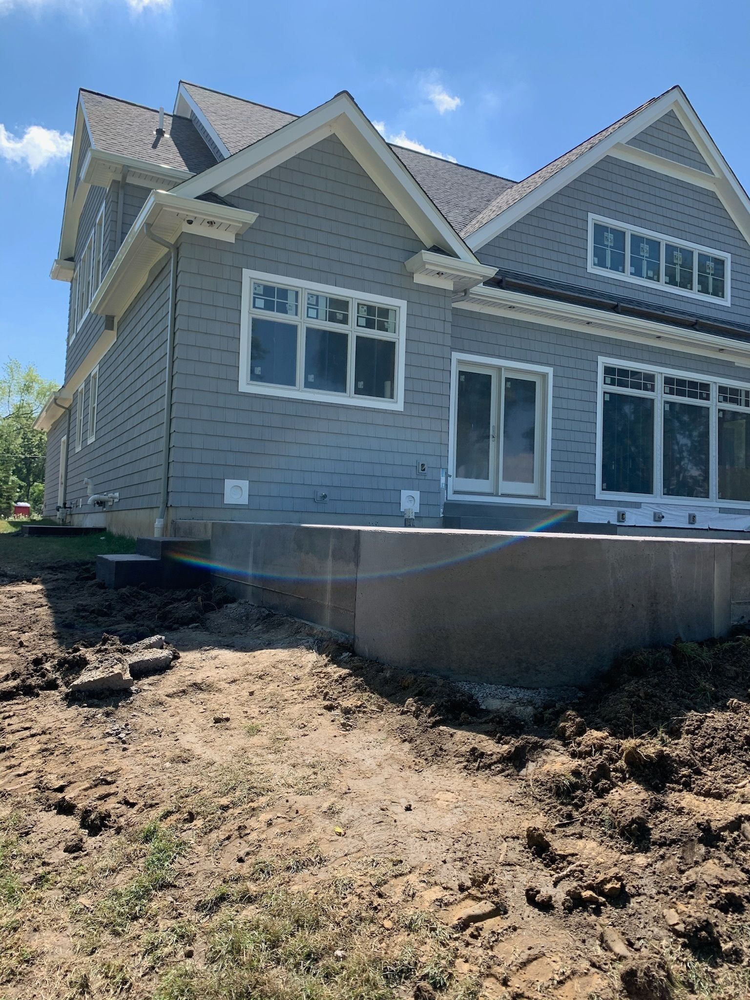 A large gray house with a lot of windows is being built.