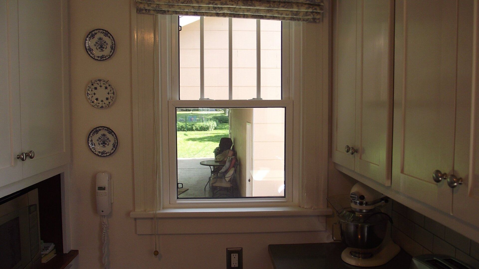 View from kitchen window; person in camouflage gear outside.