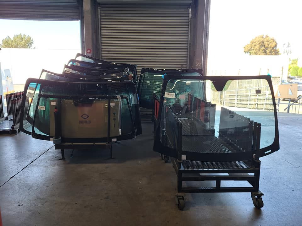 Windshields on wheeled carts inside a warehouse.