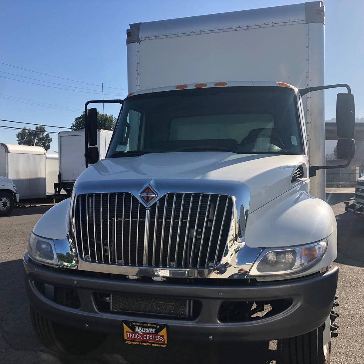 White box truck with chrome grill parked on a sunny day.