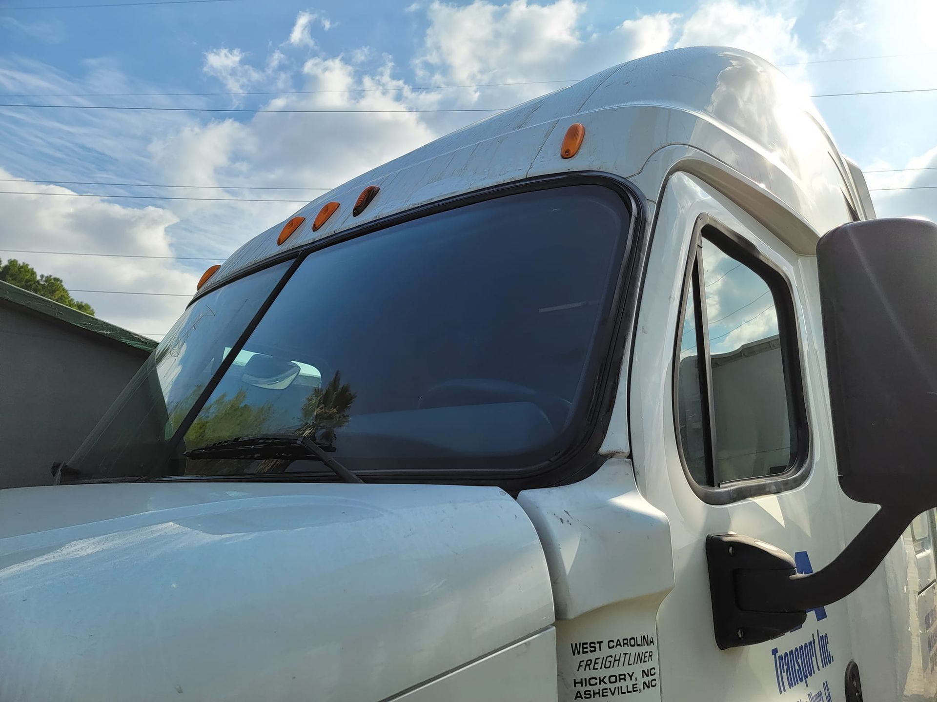 White truck cab against a cloudy blue sky.