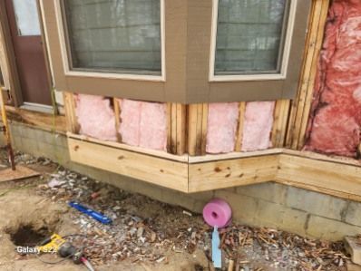A house with pink insulation on the side of it