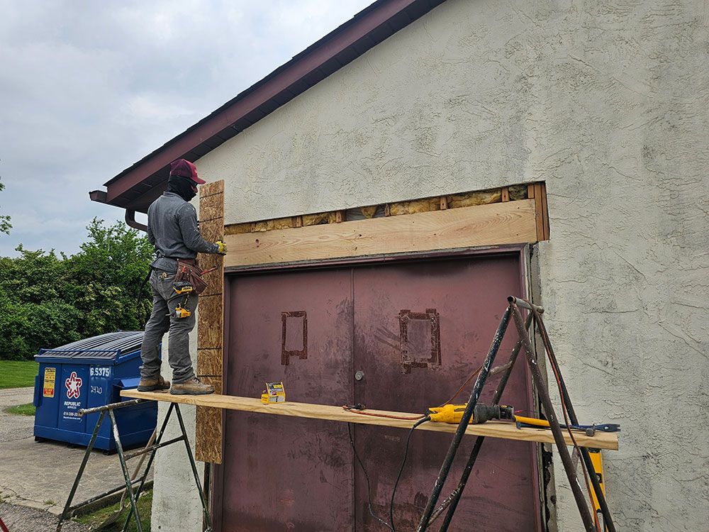 Stucco repair on a wall above garage