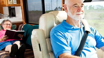 A man wearing a seat belt is sitting in the back seat of an RV.