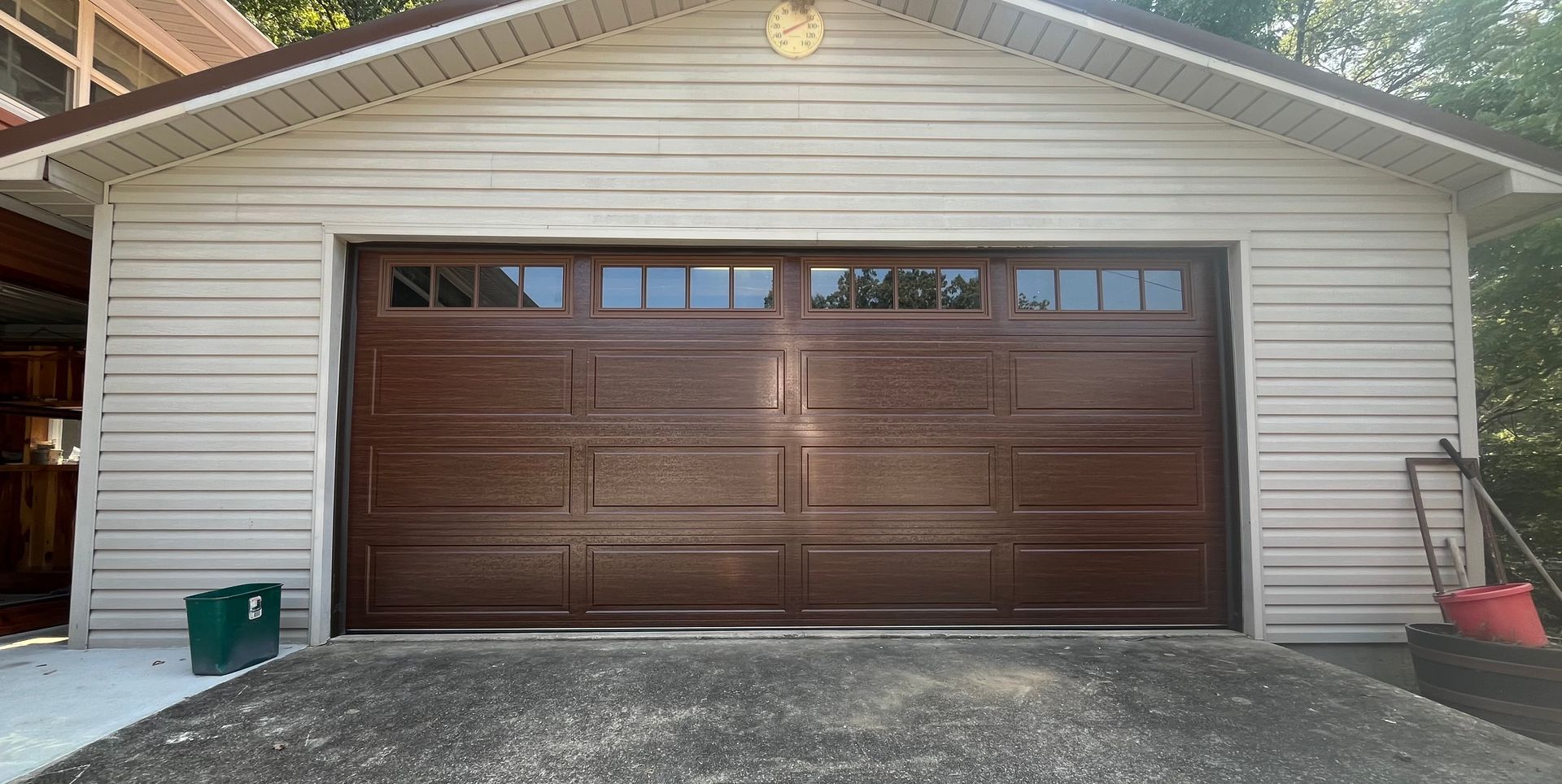 White garage with a dark brown double door and a concrete driveway in front