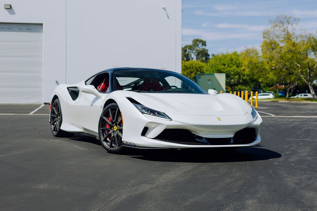 White sports car parked outside a building on a sunny day