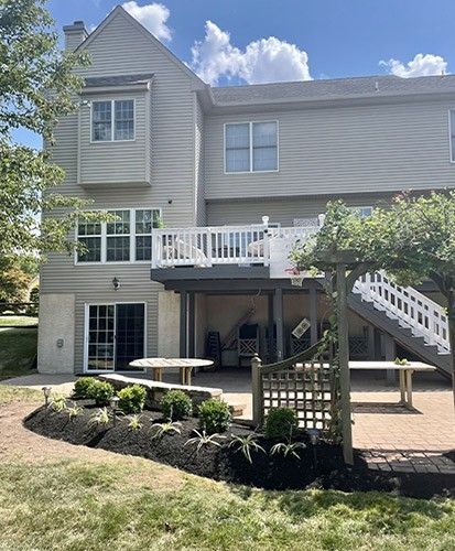 The back of a house with a large deck and stairs.