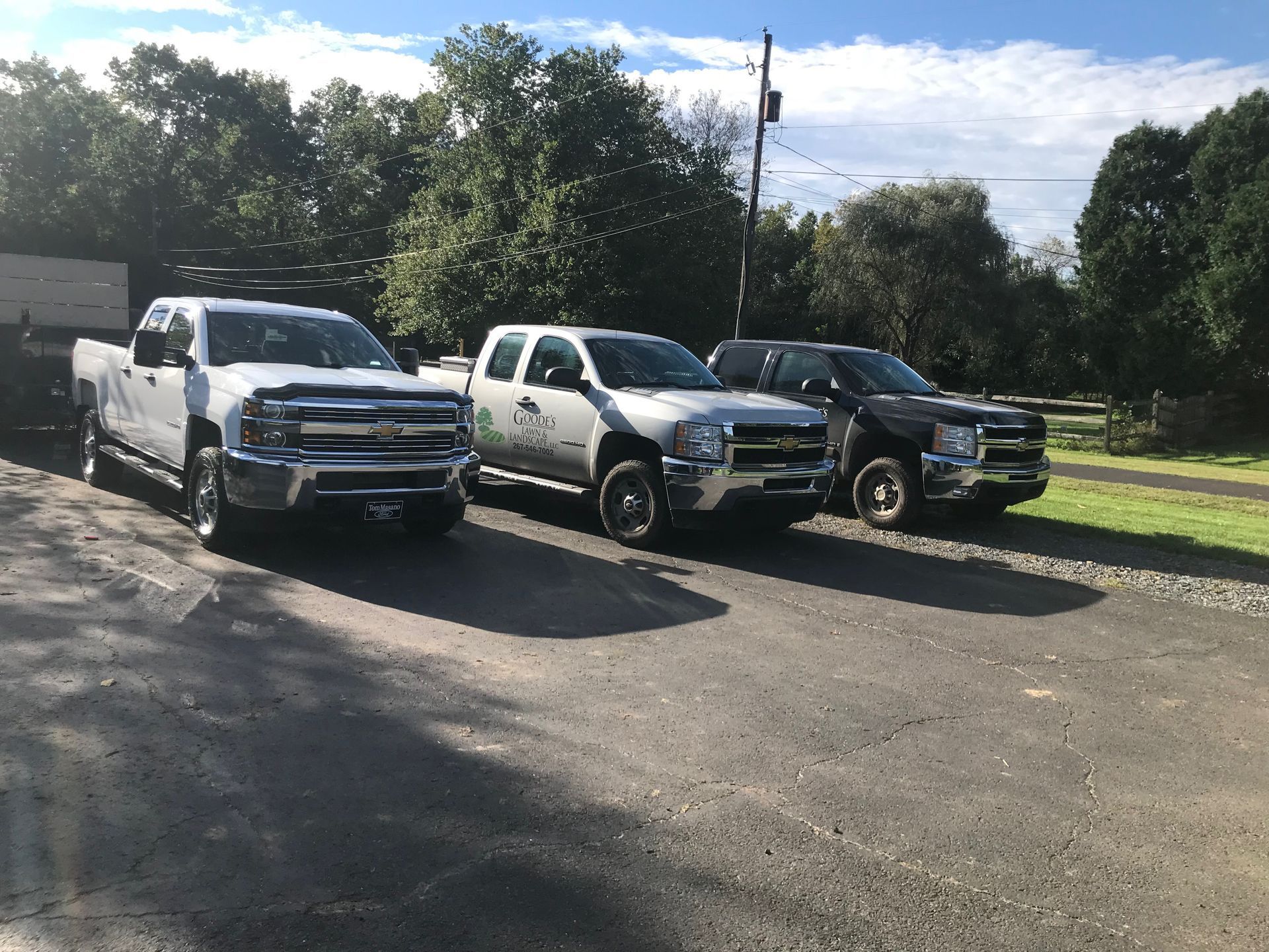 Three trucks are parked next to each other in a parking lot.