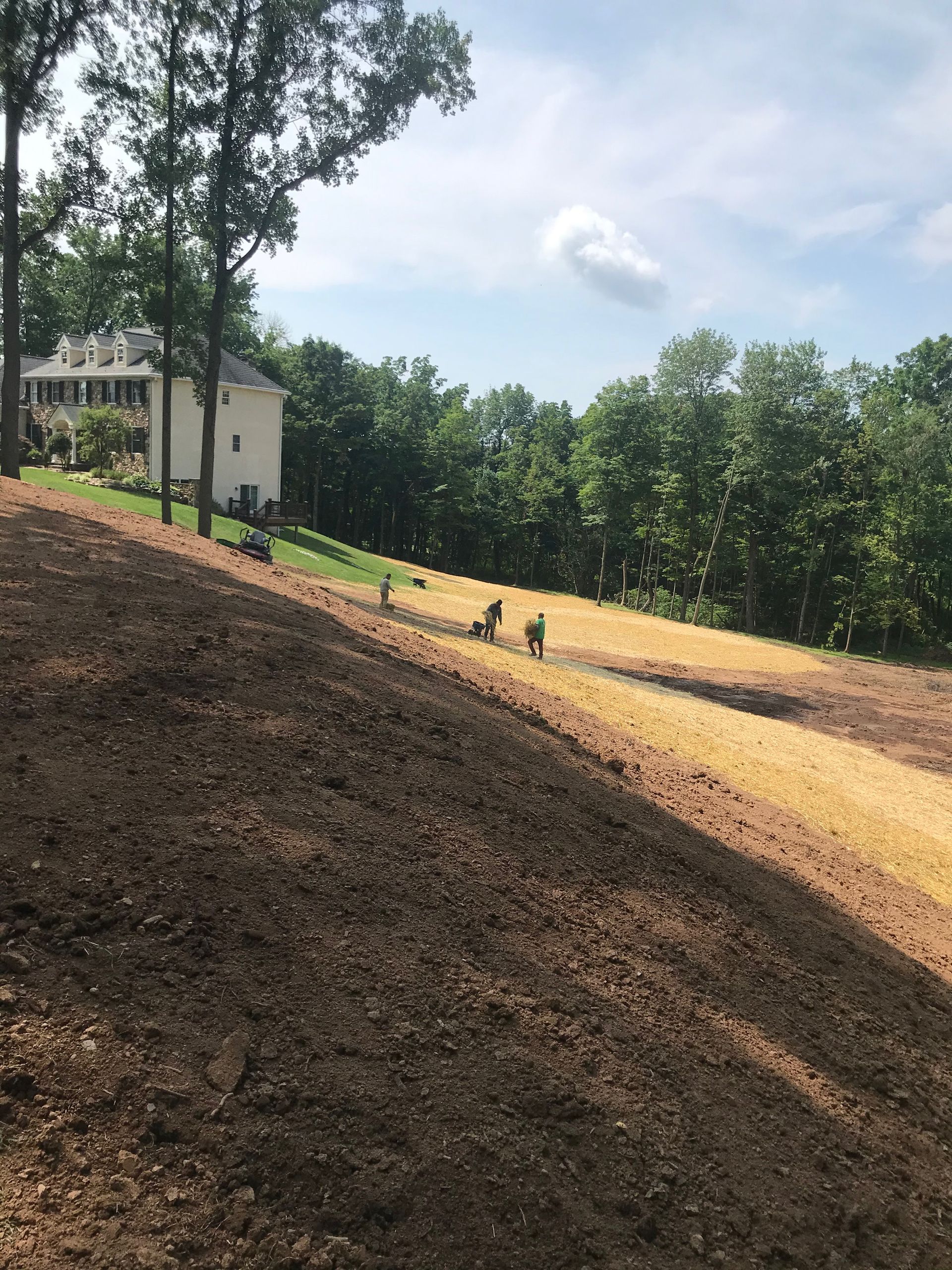 A dirt hill with a house in the background