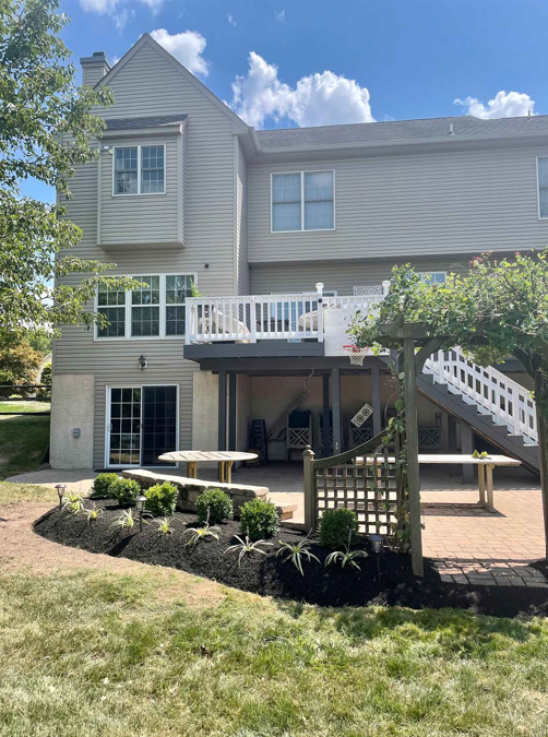 The back of a house with a large deck and stairs.