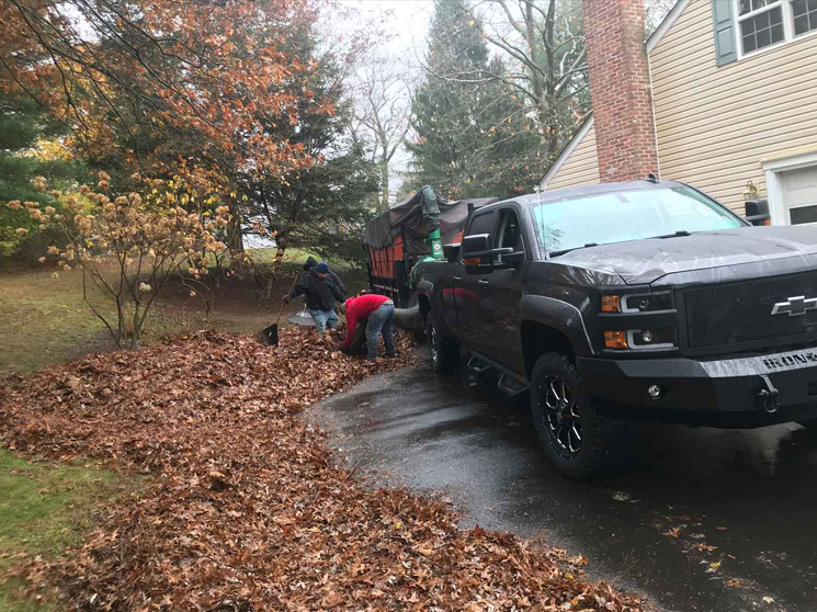 A black truck is parked in a driveway next to a house.