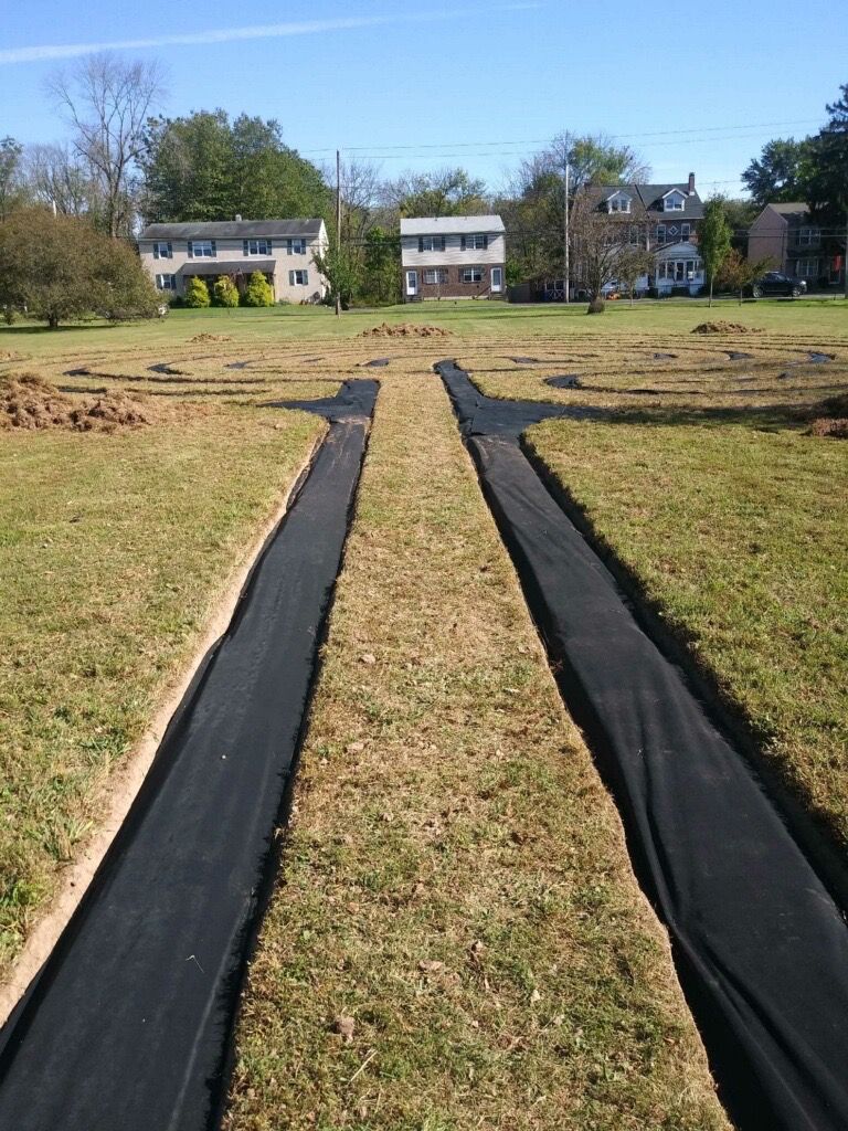 A grassy field with a house in the background