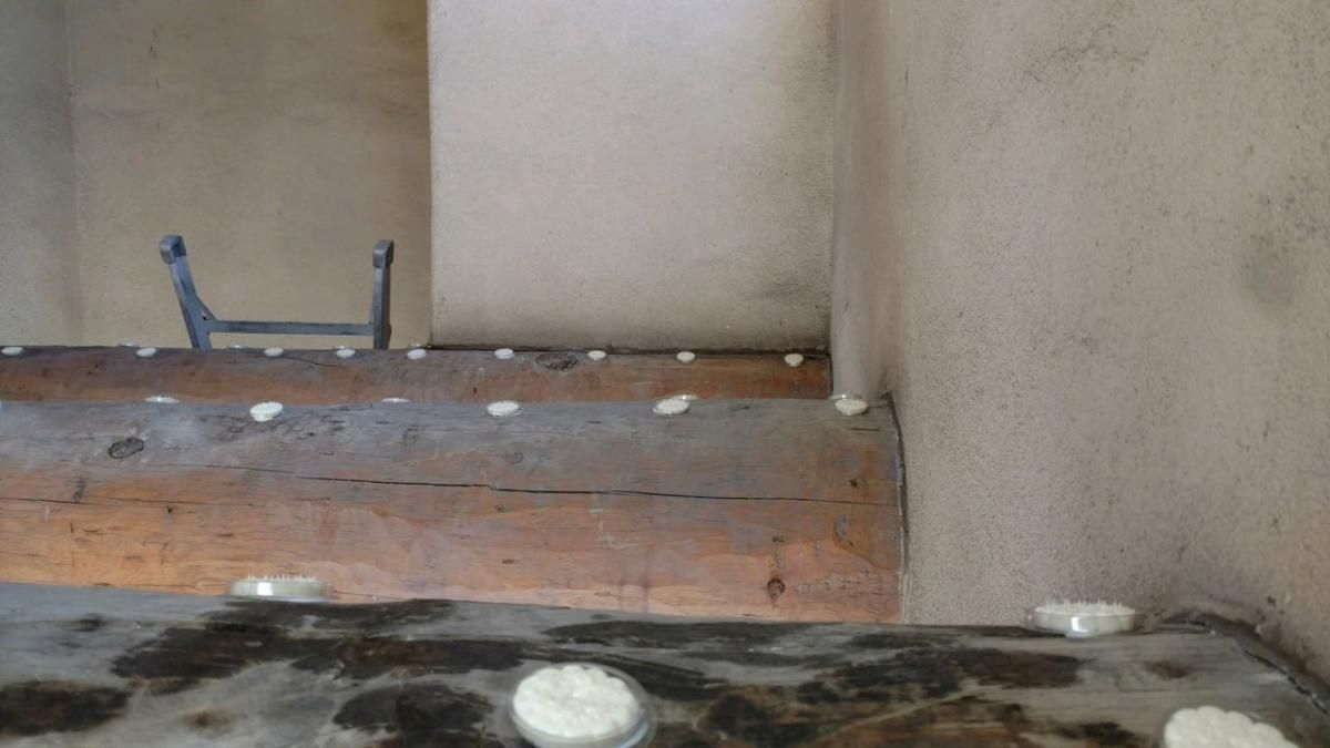 A room with a wooden floor and a ladder in the corner.