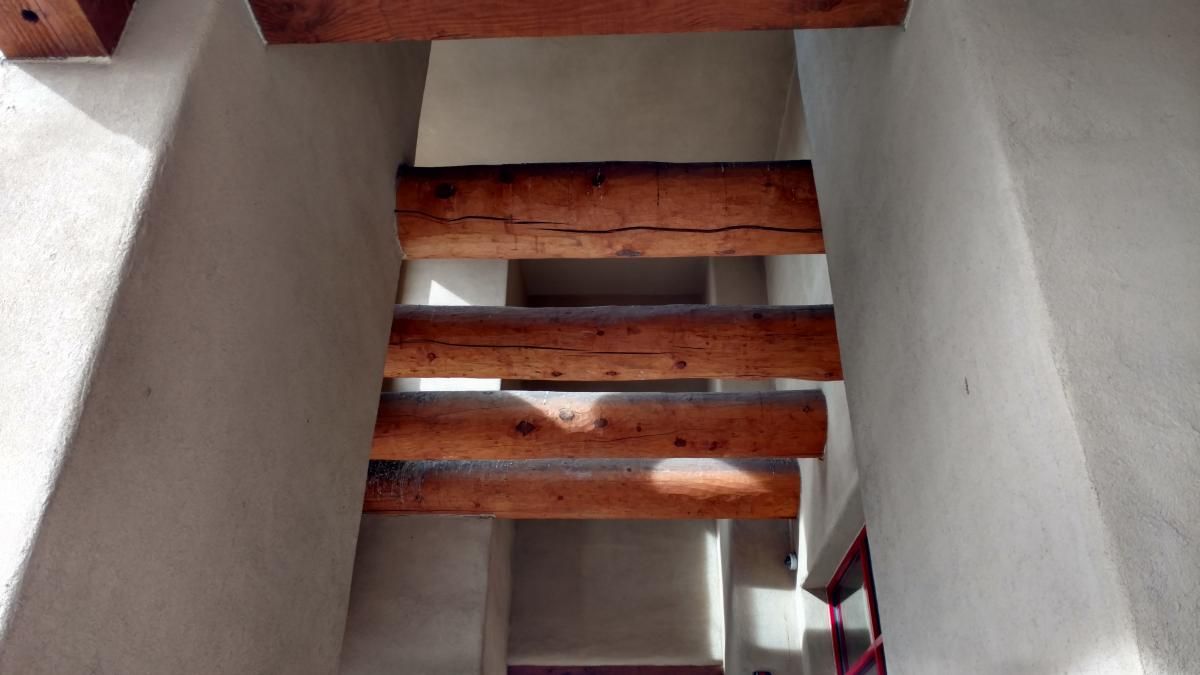 A staircase with wooden beams going up to the second floor.