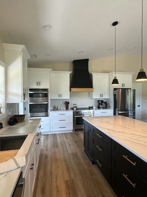 A kitchen with white cabinets and black appliances