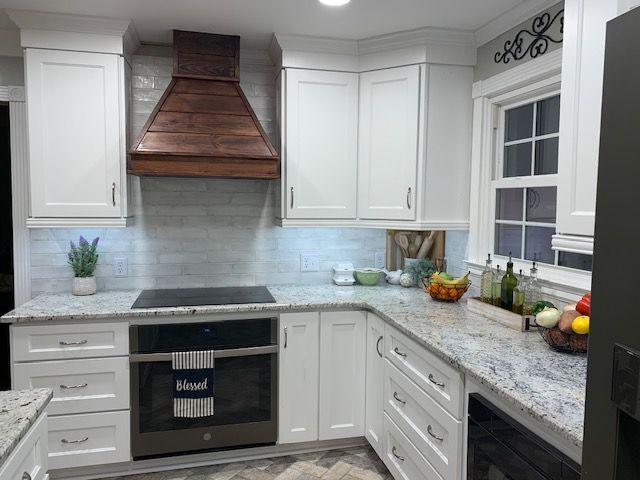 A kitchen with white cabinets and granite counter tops