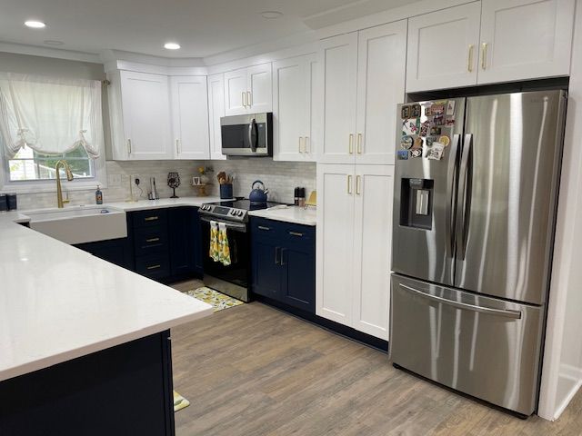 A kitchen with white cabinets and stainless steel appliances.