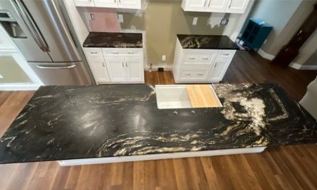 A kitchen with a black granite counter top and a sink.