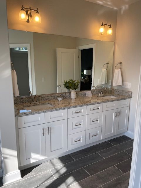 A bathroom with two sinks and a large mirror.