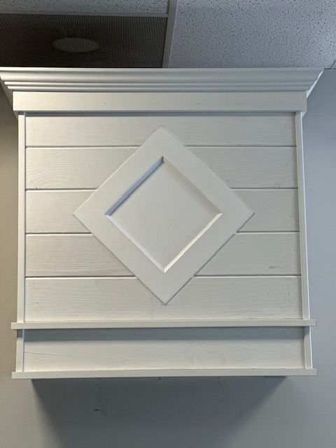 A white cabinet with a diamond in the middle of it