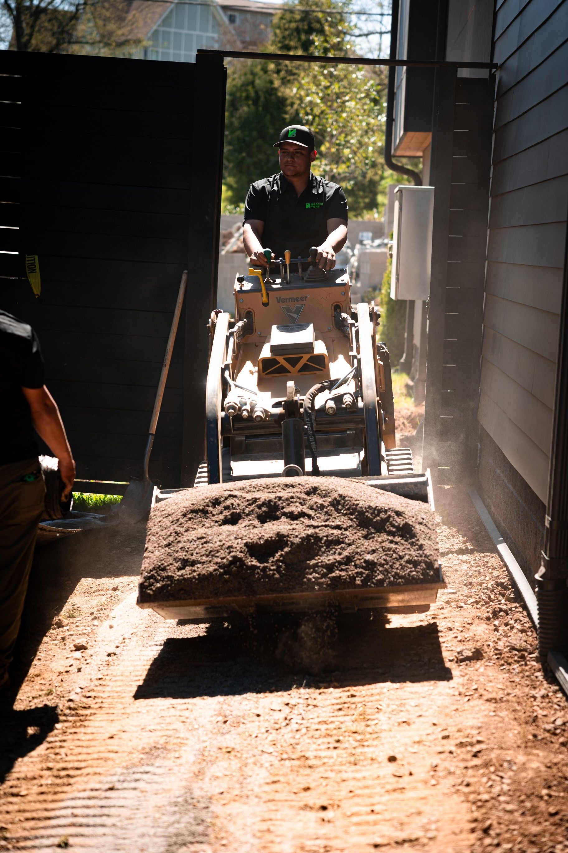 A man is driving a skid loader 