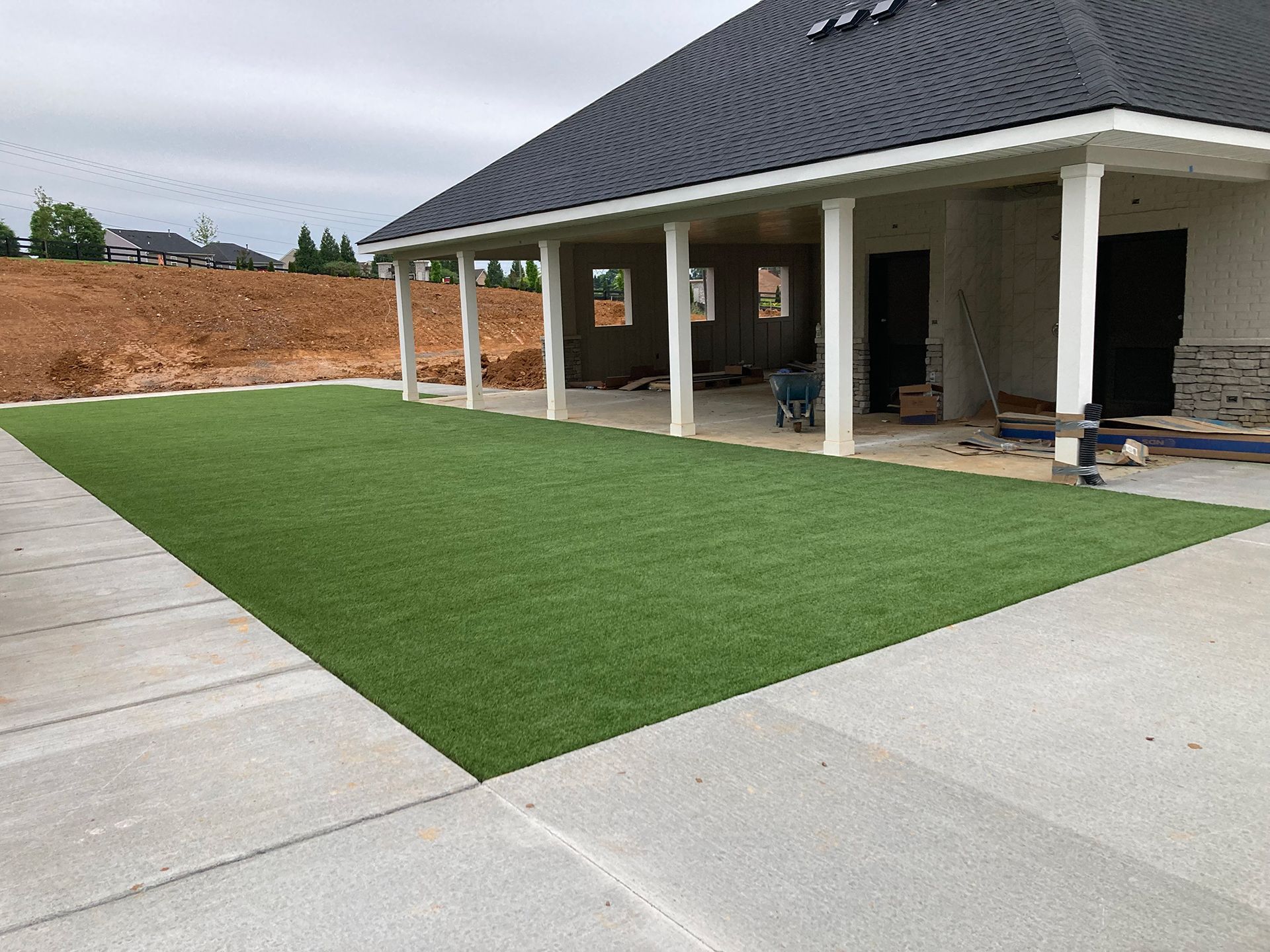 A house under construction with a large lawn in front of it