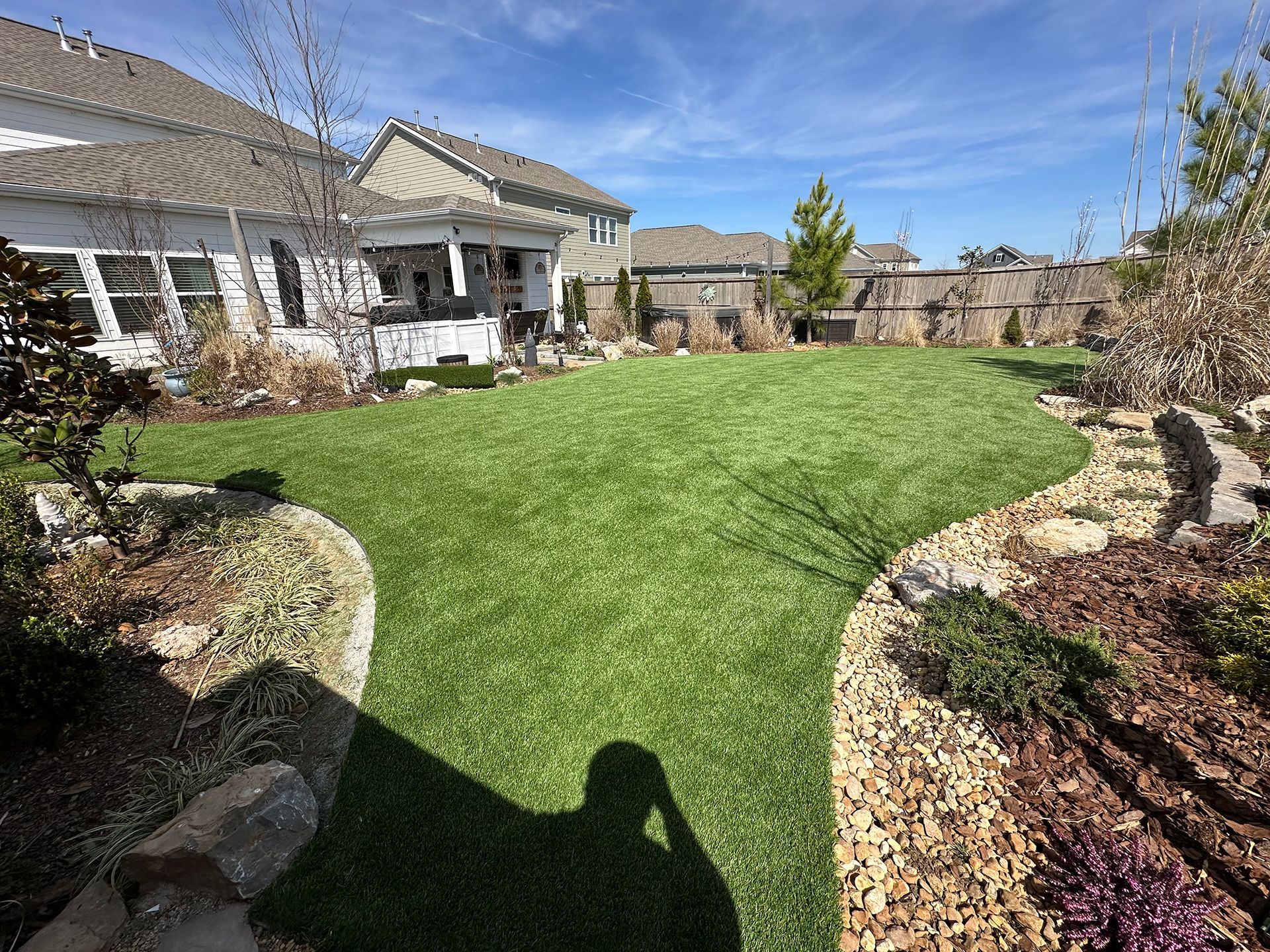 A large lush green lawn in front of a house on a sunny day