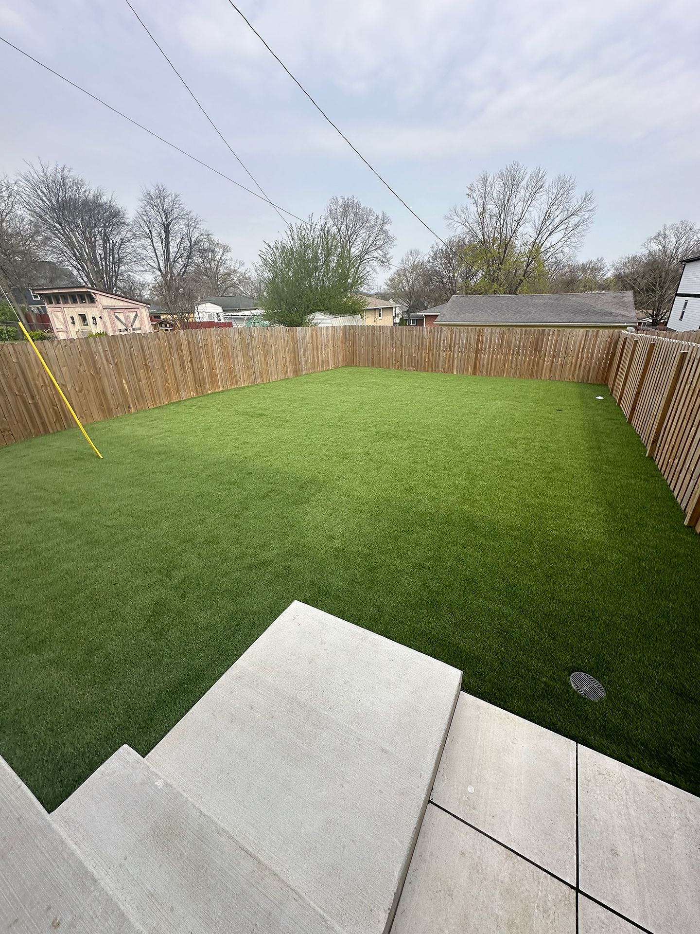Lush green lawn and a wooden fence