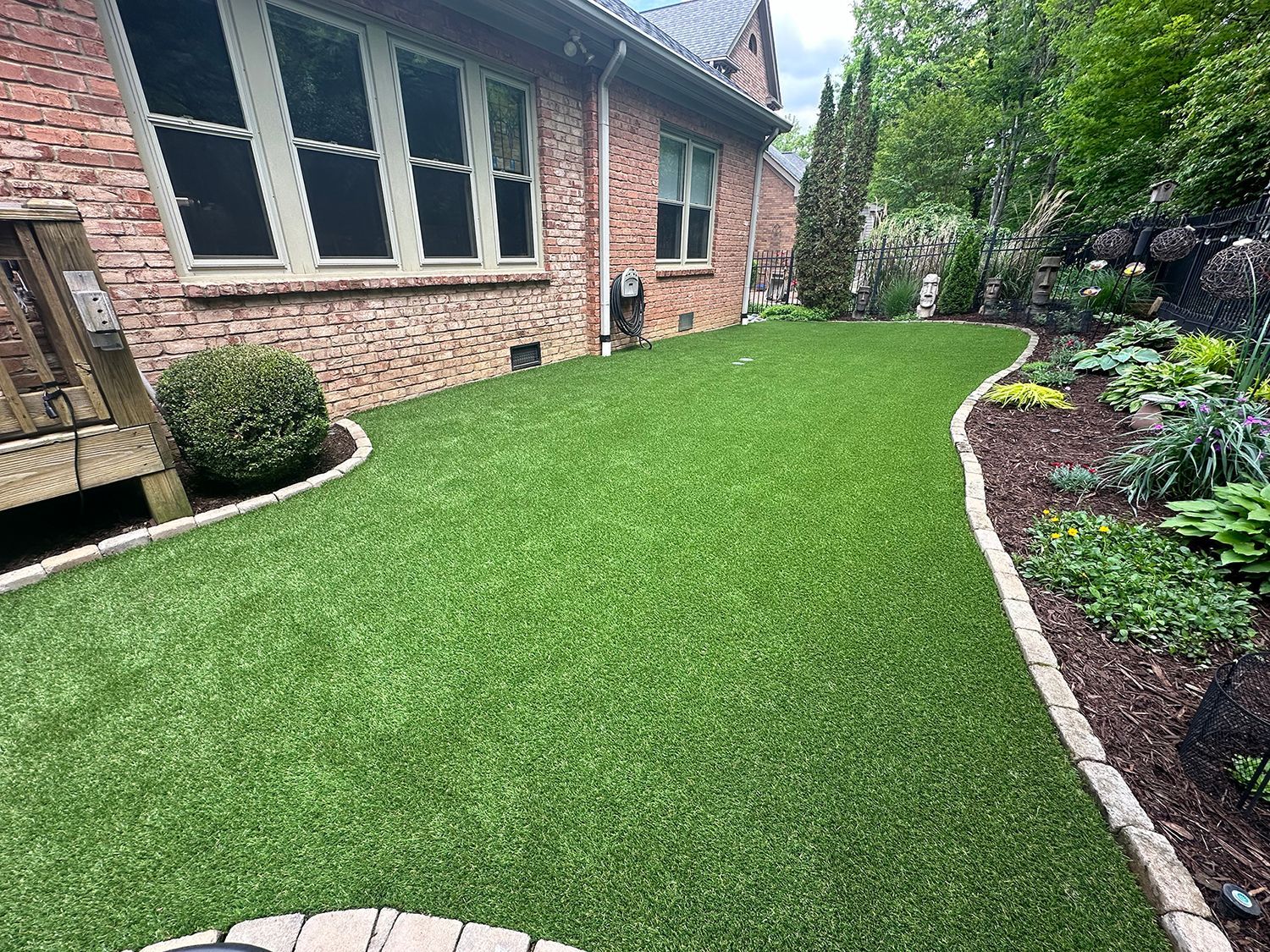 A brick house with a lush green lawn in front of it