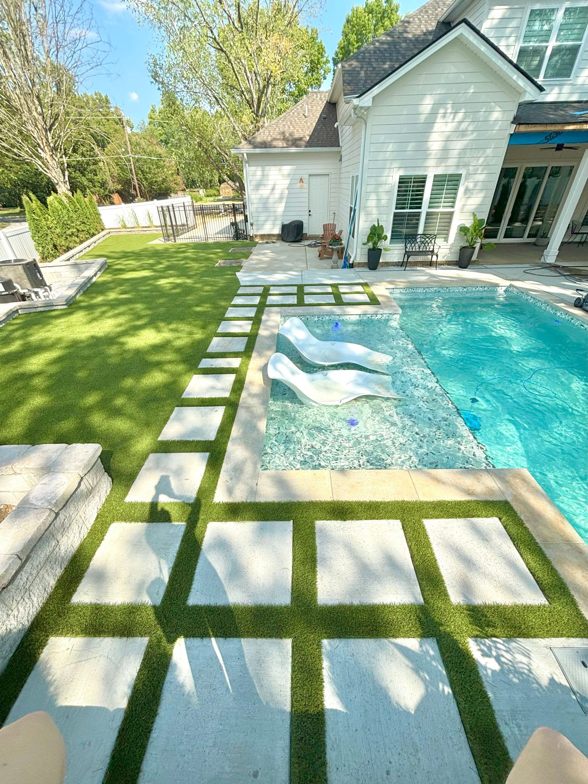 There is a swimming pool in the backyard of a house.