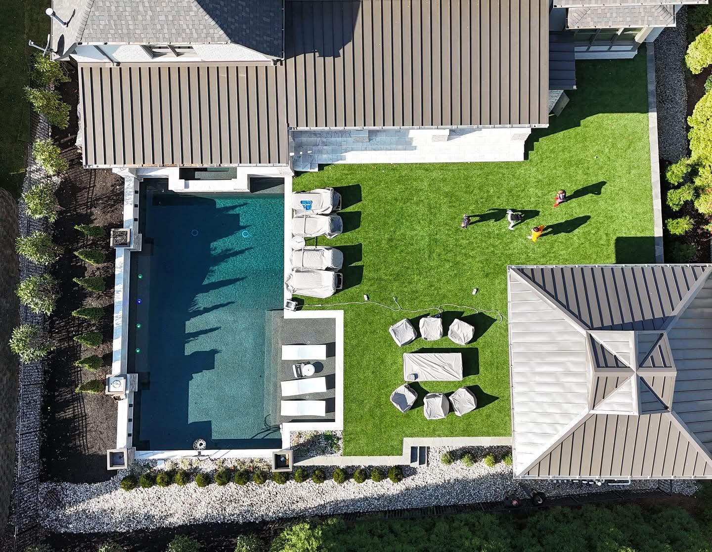 An aerial view of a house with a large swimming pool