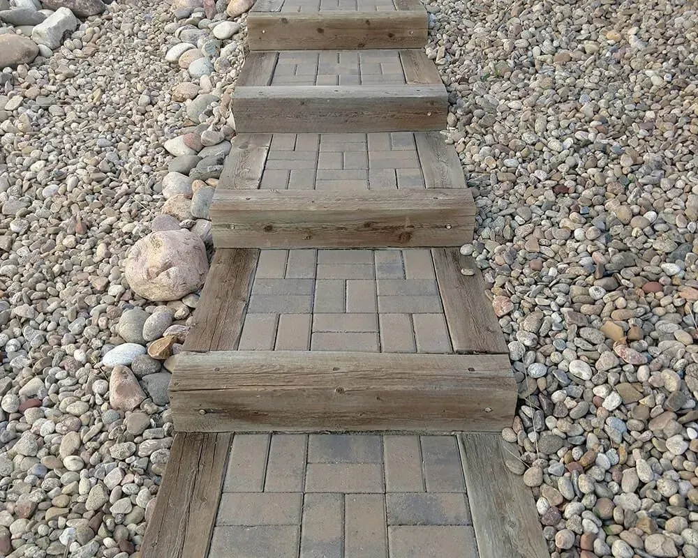 Stone steps with brick treads surrounded by gravel.