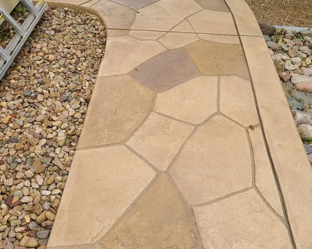 Beige and brown flagstone walkway with gravel border.