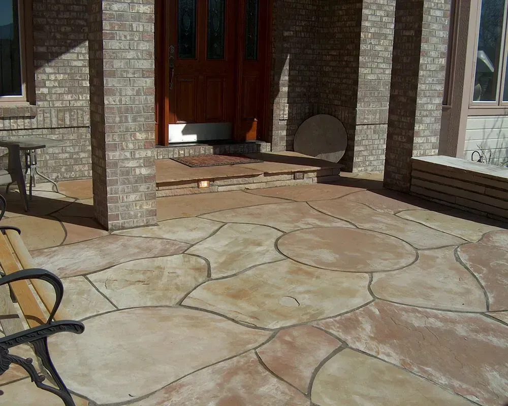 Stone patio with brick columns and wooden door.
