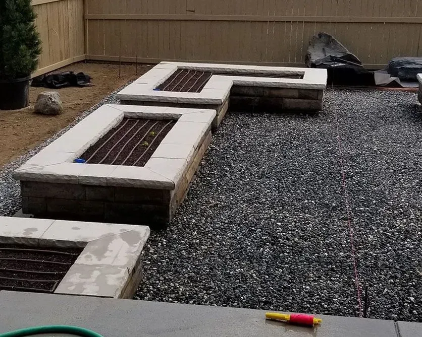Stone fire pit built on gravel patio.