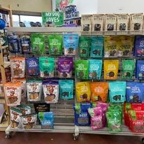 A shelf filled with bags of dog food in a store.