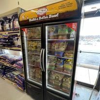 A refrigerator filled with dog food in a store.