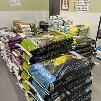 A bunch of bags of dog food are stacked on top of each other in a room.