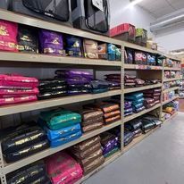 A row of shelves filled with bags of dog food in a store.