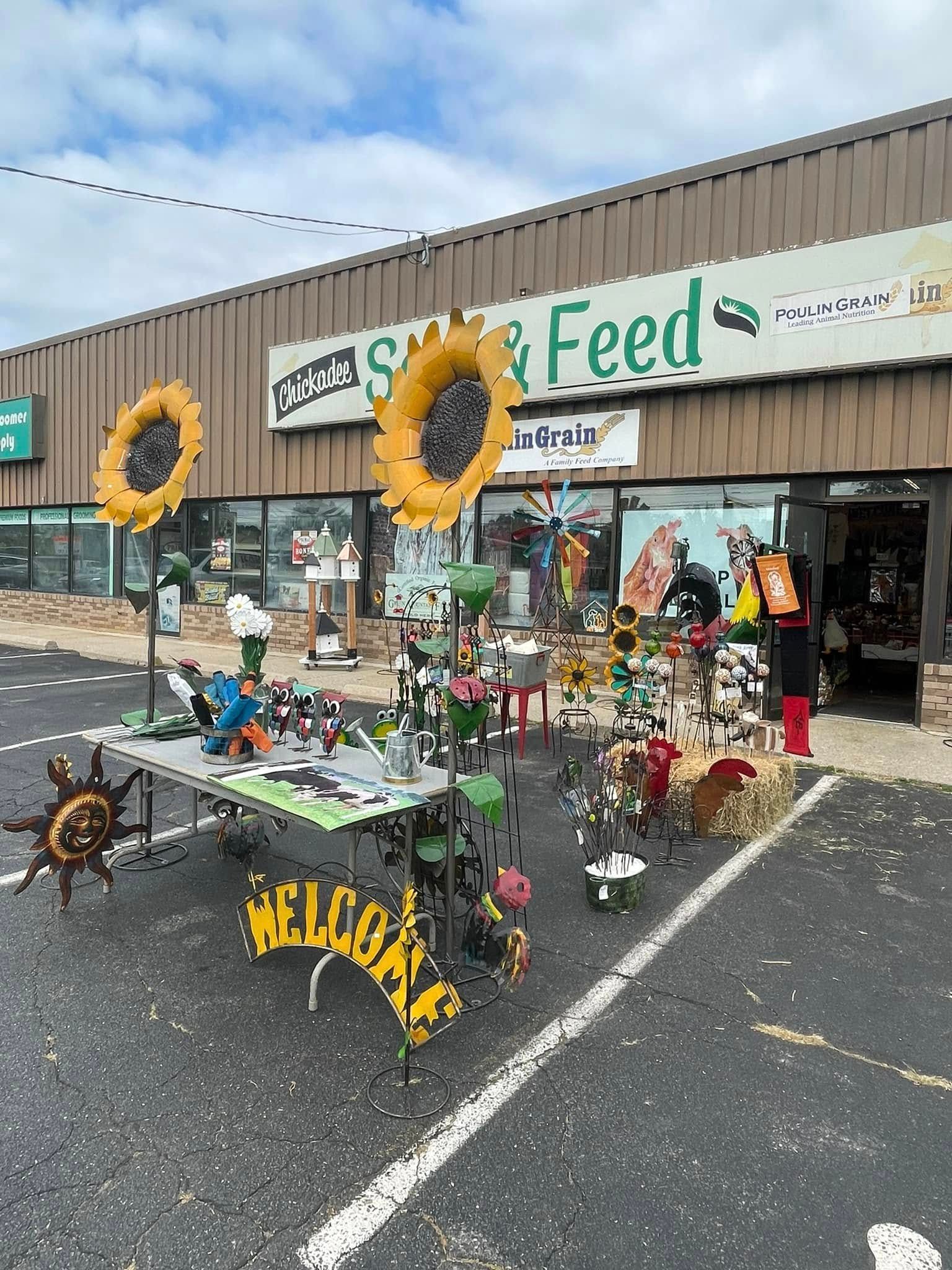A store front with sunflowers and a table in front of it.