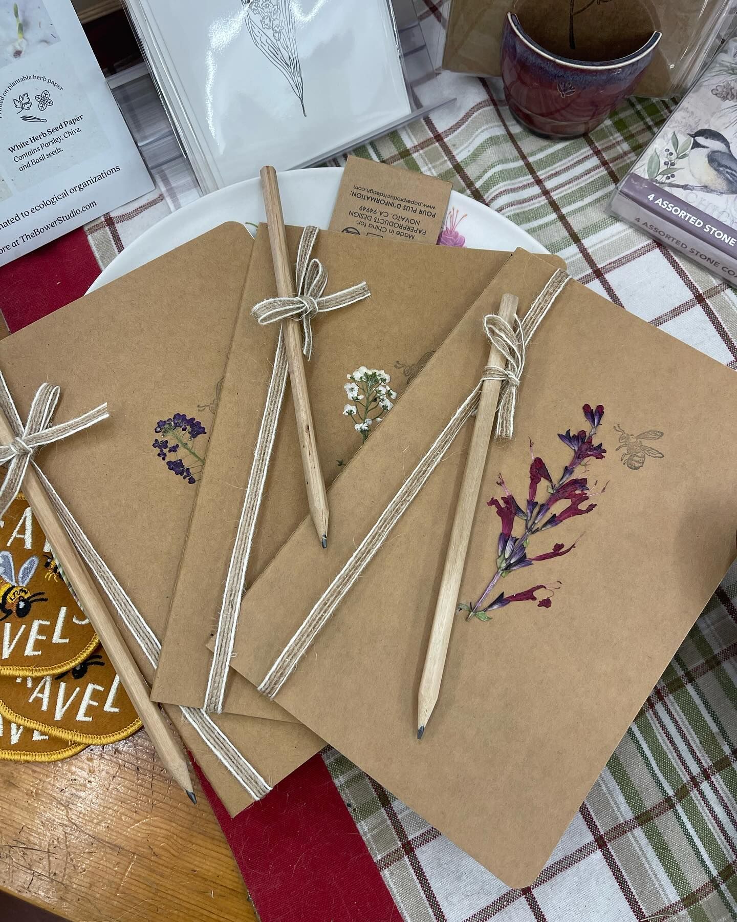A stack of brown notebooks and pencils on a table.