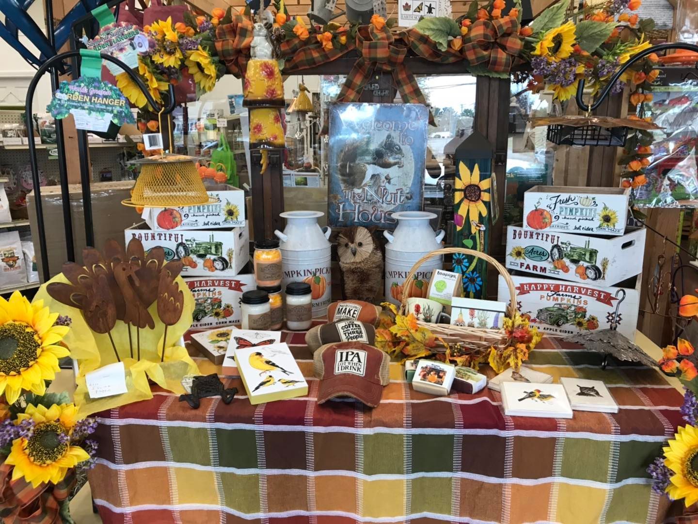 A table with a checkered tablecloth and a variety of items on it.