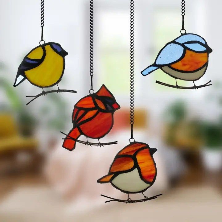 Four stained glass birds are hanging from a chain