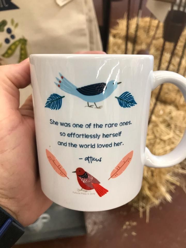 A person is holding a coffee mug that says she was one of the rare ones so effortlessly herself and the world loved her