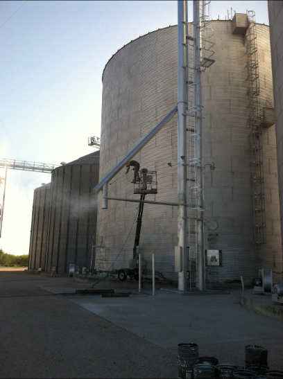 Grain silos with a conveyor belt and ladder. Exterior shot.
